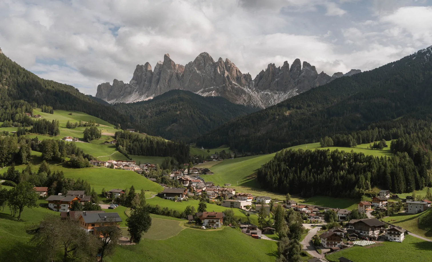 Autumn hike in Villnöß-Luson: golden larch forests and rugged Dolomite peaks under blue sky