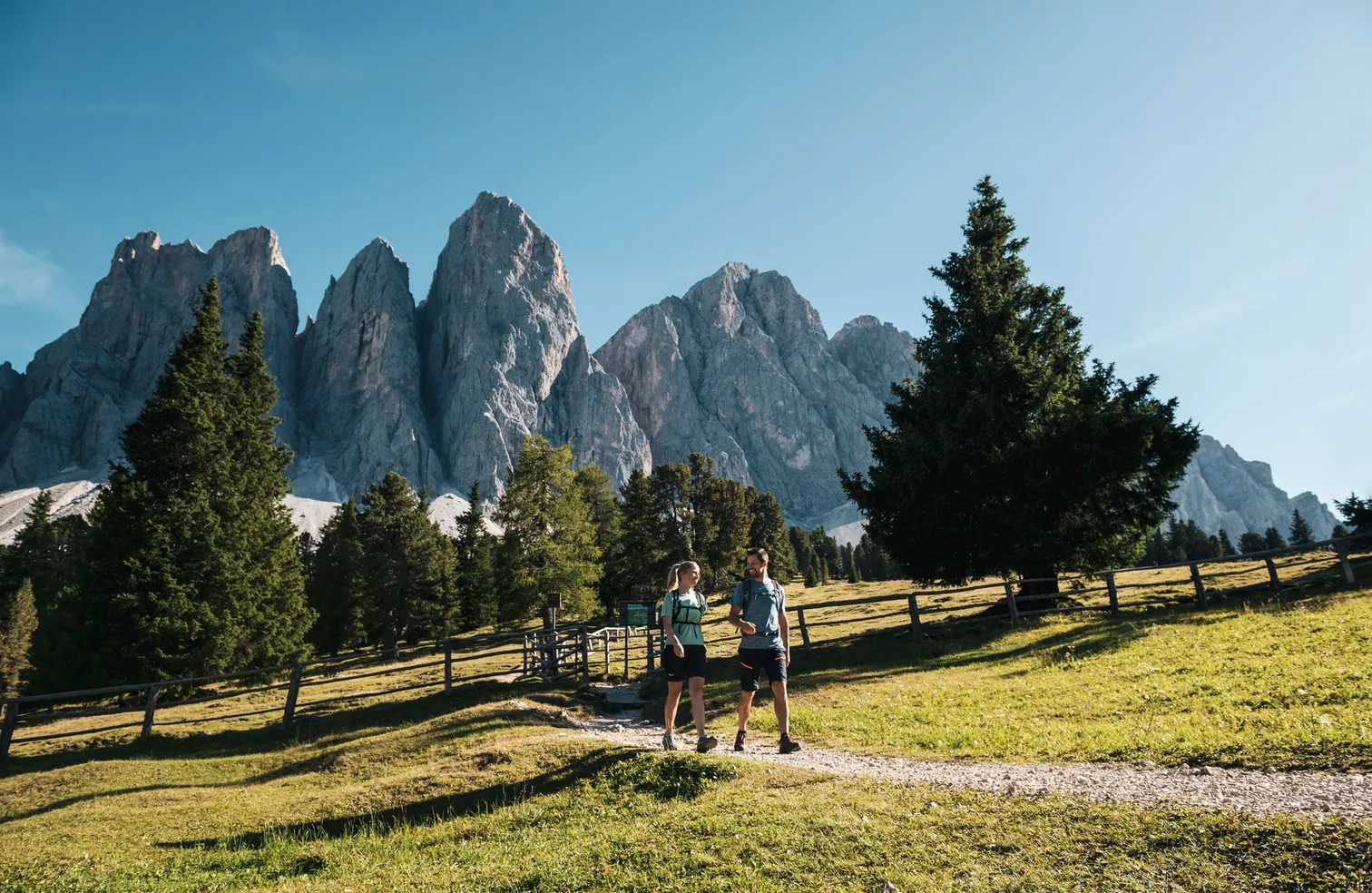 Wanderer vor dem Geislerpanorama im Naturpark Puez-Geisler – majestätische Dolomitengipfel in Villnöß