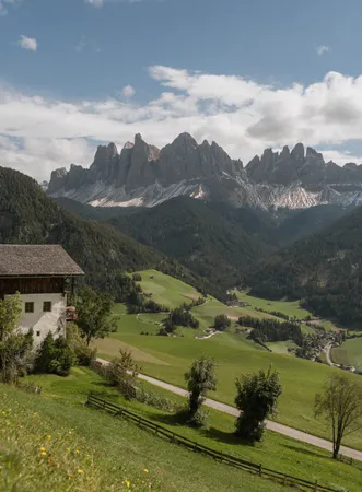 Autumnal sea of fog over the Luson mountain forest at sunrise, peaks of the Dolomites rise above the cloud cover, South Tyrol