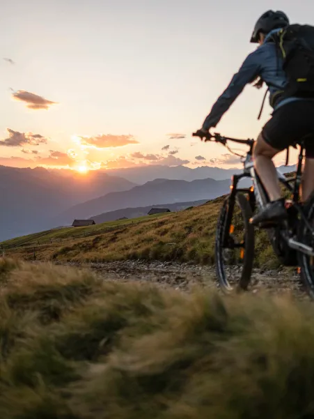 Cyclist on Luson Alp with panoramic view of Dolomite peaks in the background