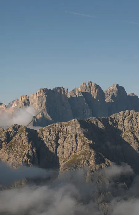 UNESCO-Welterbe Dolomiten: Panorama der Geislerspitzen im Naturpark Puez-Geisler bei Sonnenaufgang mit Nebelbänken