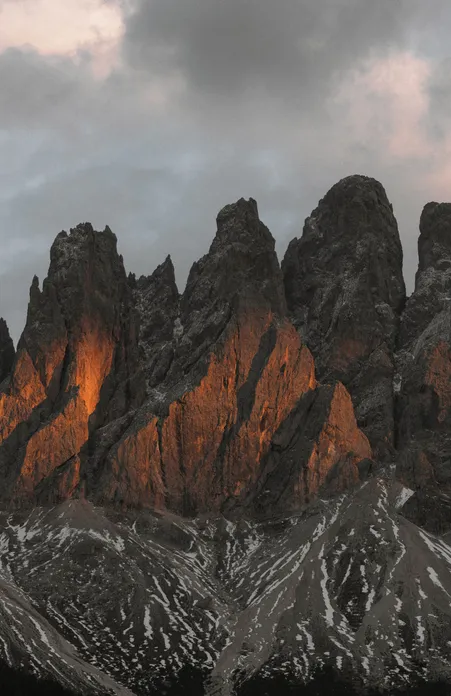 Enrosadira-Alpenglühen an den Geislerspitzen: Dolomitkalk leuchtet orange-rot beim Sonnenuntergang in Villnöß